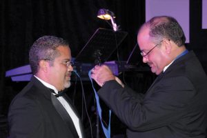 El Dr. Juan Suárez-Pesante le coloca la Medalla Presidencial al nuevo Presidente de SPOT, Dr. Ónix Reyes Martínez.